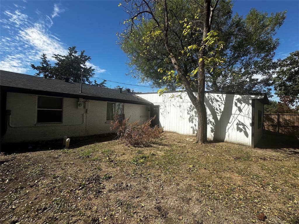 4808 Sandra Lynn Drive, Mesquite, TX 75150 Exterior featuring painted brick and vertical siding, asphalt shingle roofing, and a wood privacy fence