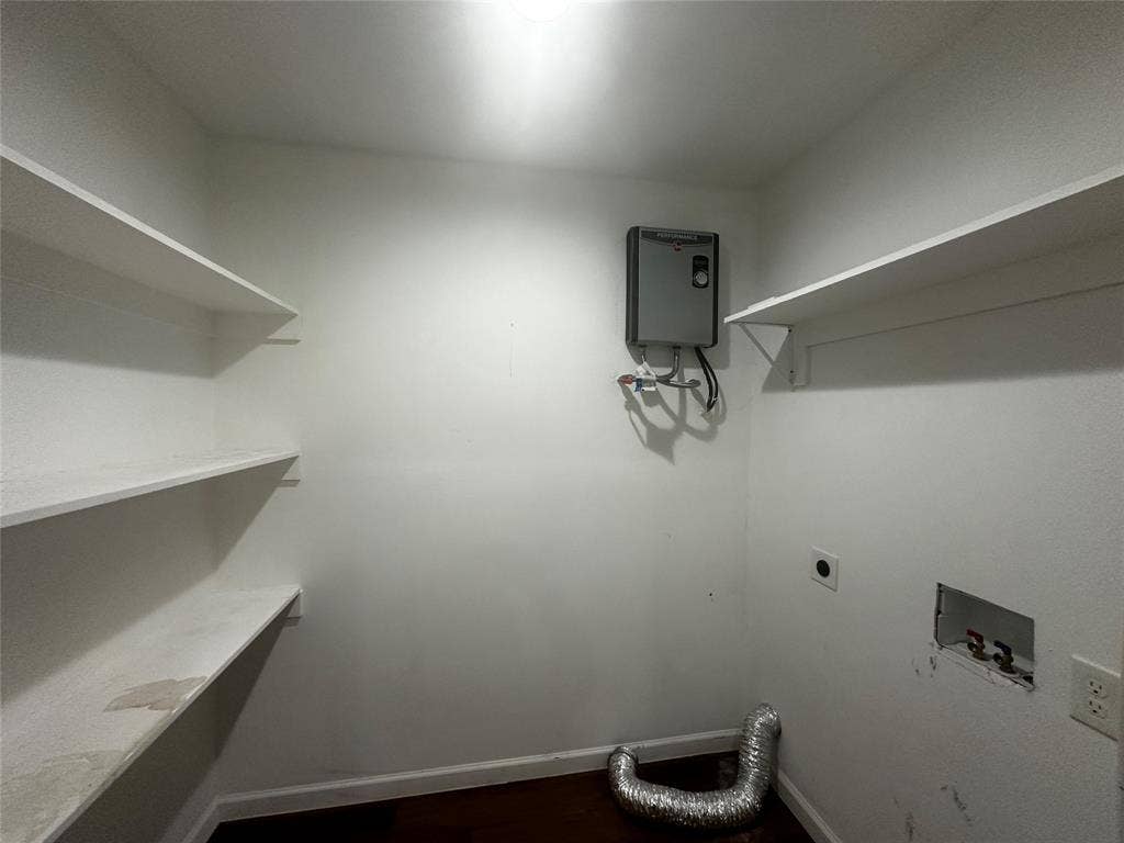 4808 Sandra Lynn Drive, Mesquite, TX 75150 Storage area featuring three tiers of built-in shelving, wall-mounted water heater unit, and dedicated utility hookups