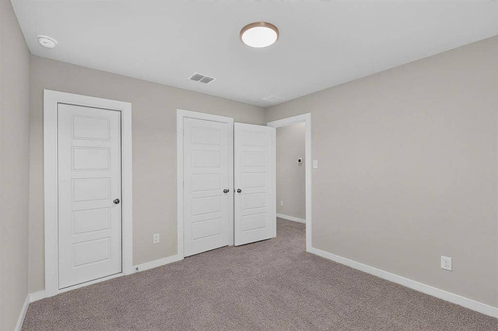 6001 Kaitlynn Drive, Princeton, TX 75071 Neutral interior featuring gray carpeting, soft gray wall paint, five-panel interior doors, and a flush-mount circular ceiling fixture