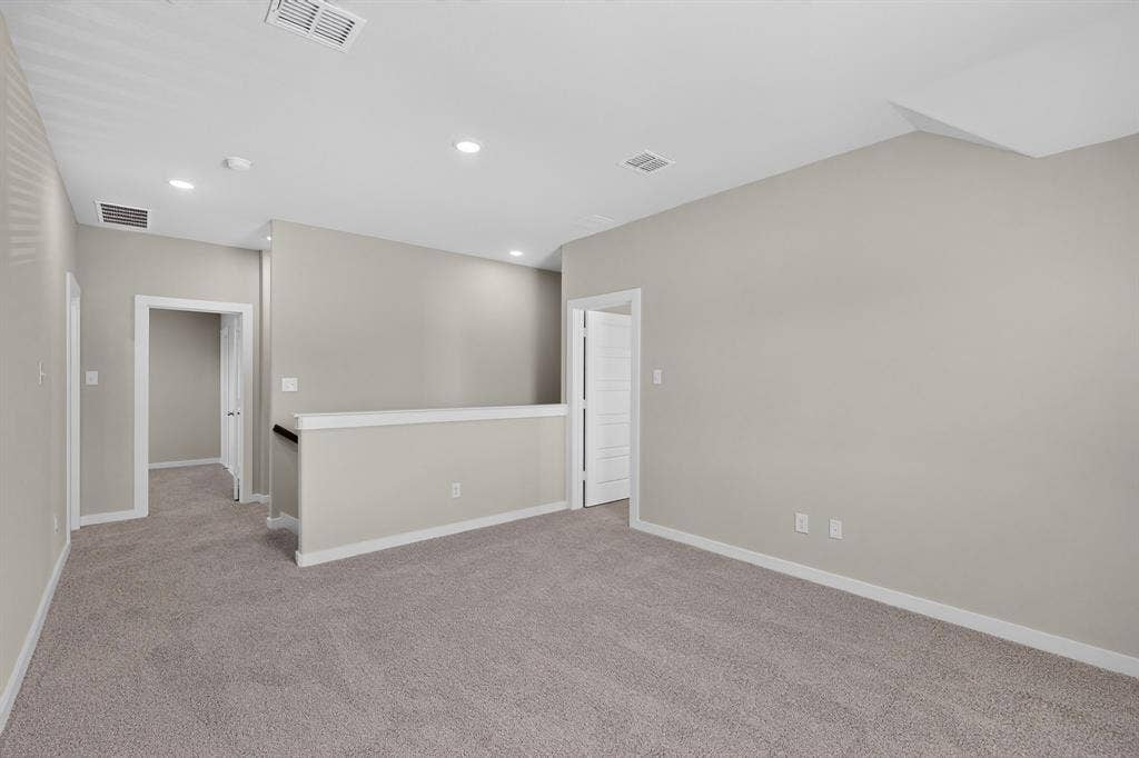 6001 Kaitlynn Drive, Princeton, TX 75071 Interior space featuring neutral wall tones, wall-to-wall carpeting, recessed ceiling lighting, and a half-height partition wall with a dark handrail
