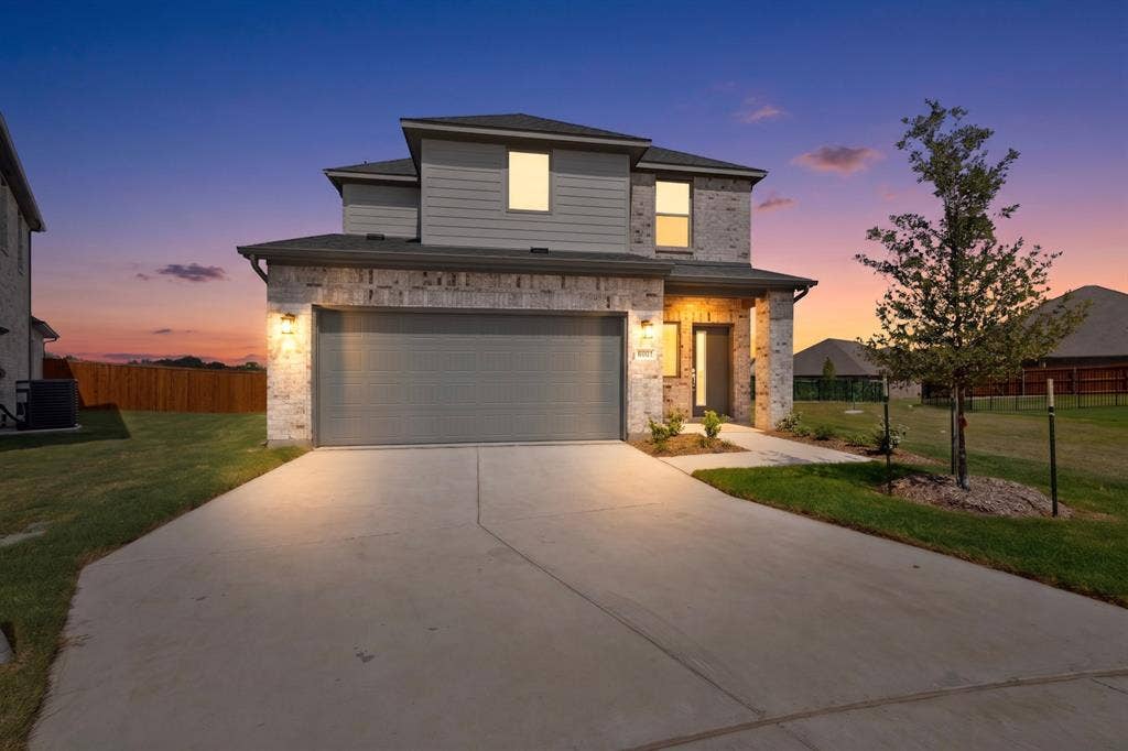 6001 Kaitlynn Drive, Princeton, TX 75071 Two-story residence featuring a combination of brick and horizontal siding exterior, a two-car garage, and a concrete driveway