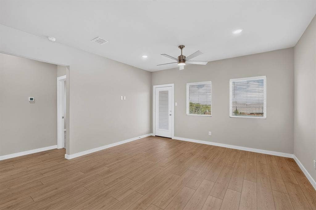6001 Kaitlynn Drive, Princeton, TX 75071 Living area featuring wood-finish flooring, recessed lighting, a ceiling fan with integrated light, two windows with horizontal blinds, and a glass-panel exterior door