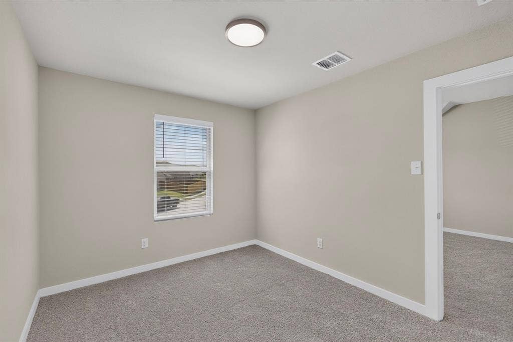 6001 Kaitlynn Drive, Princeton, TX 75071 Neutral-toned interior space featuring wall-to-wall carpeting, a single-hung window with horizontal blinds, and a central flush-mount ceiling light fixture