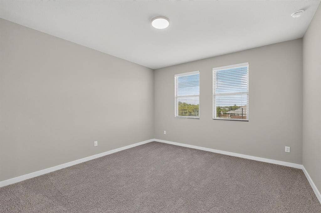 6001 Kaitlynn Drive, Princeton, TX 75071 Neutral-toned interior space featuring neutral wall paint, wall-to-wall carpeting, dual windows, and a flush-mount ceiling light fixture