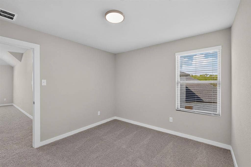 6001 Kaitlynn Drive, Princeton, TX 75071 Neutral-toned interior space featuring wall-to-wall carpeting, a single window with horizontal blinds, and a flush-mount circular ceiling light