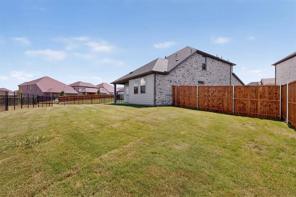 6001 Kaitlynn Drive, Princeton, TX 75071 Expansive backyard featuring a sodded lawn and privacy wood fencing