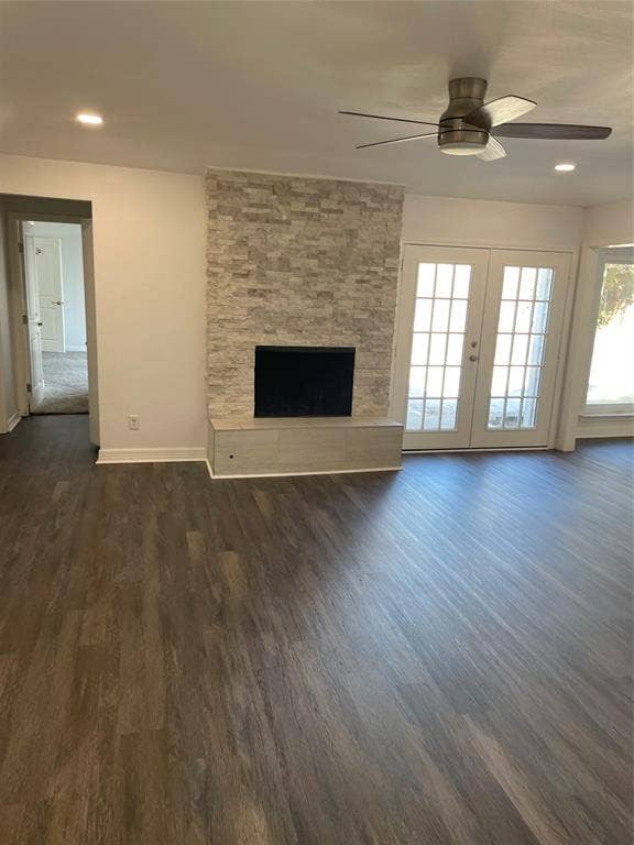 1423 Northridge Drive, Carrollton, TX 75006 Fireplace featuring a floor-to-ceiling stacked stone surround, wood-finish flooring, recessed lighting, ceiling fan, and French doors