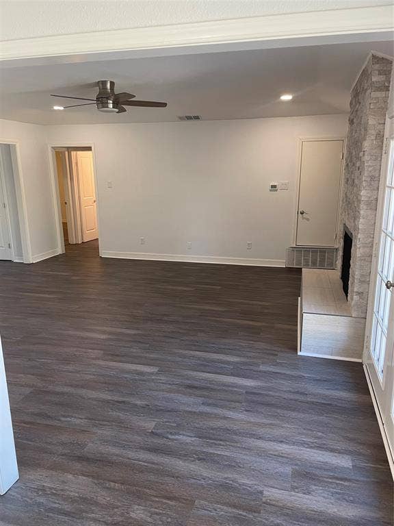 1423 Northridge Drive, Carrollton, TX 75006 Open-concept area featuring wood-finish flooring, a floor-to-ceiling stone-clad fireplace, a raised stone hearth, and a ceiling fan