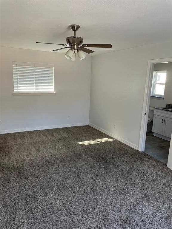1423 Northridge Drive, Carrollton, TX 75006 Interior space featuring wall-to-wall carpeting, brushed nickel ceiling fan with integrated lighting, horizontal window blinds, and a built-in white vanity with stone-top surface