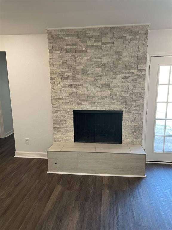 1423 Northridge Drive, Carrollton, TX 75006 Fireplace with stacked stone veneer, raised hearth, and wood-finish flooring