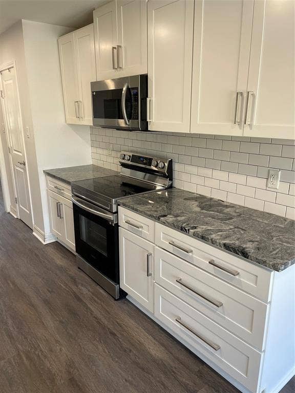 1423 Northridge Drive, Carrollton, TX 75006 Kitchen featuring white Shaker-style cabinetry, dark stone countertops, stainless steel appliances, subway tile backsplash, and wood-finish flooring
