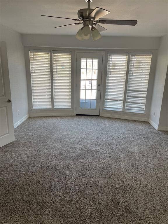 1423 Northridge Drive, Carrollton, TX 75006 Wall-to-wall carpeting, four large windows, glass-paneled exterior door, and a ceiling fan with integrated lighting