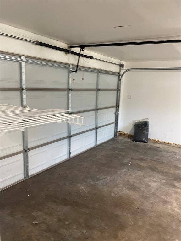 1423 Northridge Drive, Carrollton, TX 75006 Garage featuring a sectional overhead door, automatic door opener mechanism, and built-in wire shelving