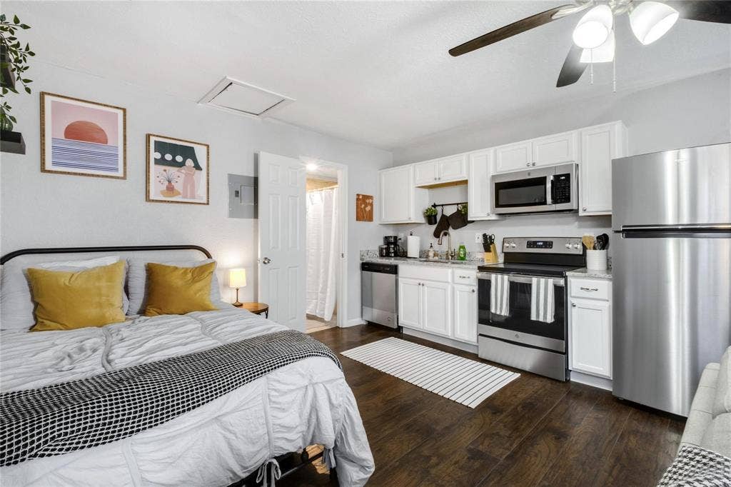 1227 Wilbur Street, Dallas, TX 75224 White cabinetry, stainless steel appliances, wood-finish flooring, and ceiling fan