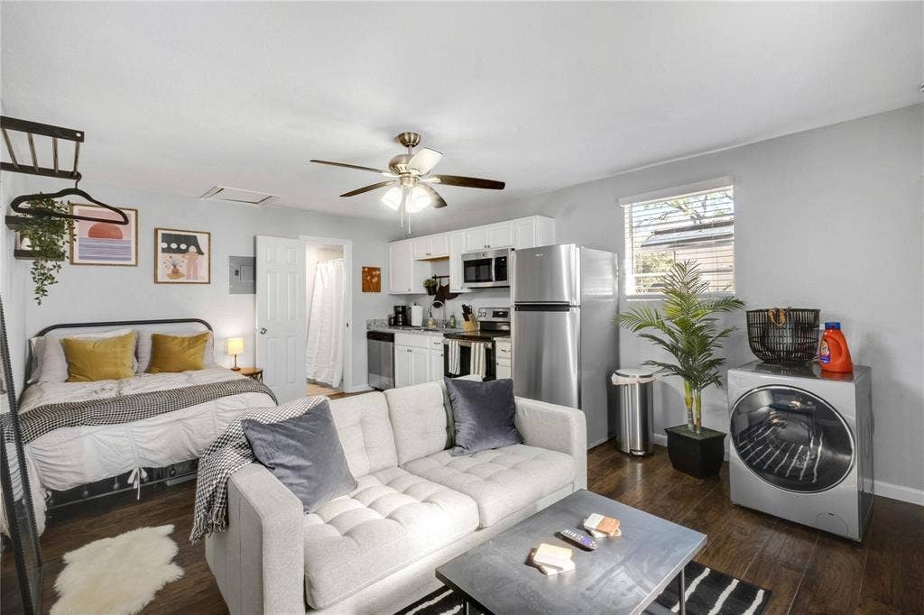 1227 Wilbur Street, Dallas, TX 75224 Kitchenette featuring white cabinetry, stainless steel appliances, wood-finish flooring, and a ceiling fan with integrated lighting
