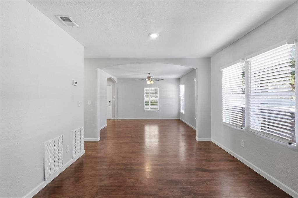 1227 Wilbur Street, Dallas, TX 75224 Open-concept interior featuring wood-finish flooring, an arched entryway, recessed lighting, and horizontal window blinds