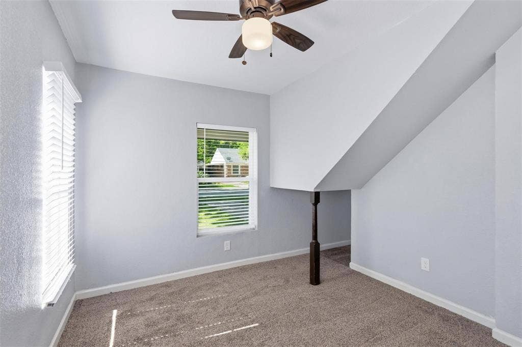 1227 Wilbur Street, Dallas, TX 75224 Neutral wall coloring with carpeted flooring, a ceiling fan with integrated lighting, and a dark-toned decorative support column