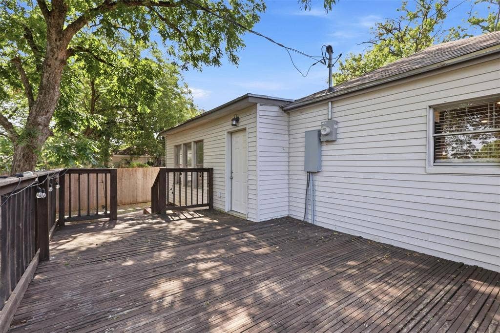 1227 Wilbur Street, Dallas, TX 75224 Exterior deck featuring horizontal wood-plank decking, wood railing, and siding construction