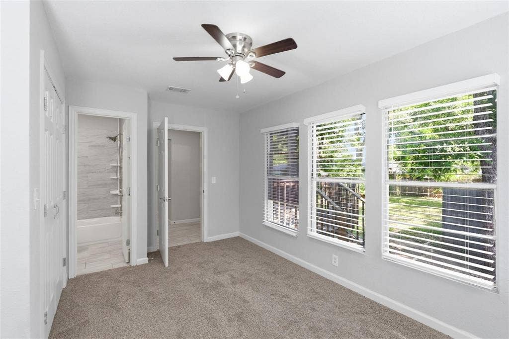 1227 Wilbur Street, Dallas, TX 75224 Neutral-toned room featuring wall-to-wall carpeting, a multi-light ceiling fan, and three large windows with horizontal blinds