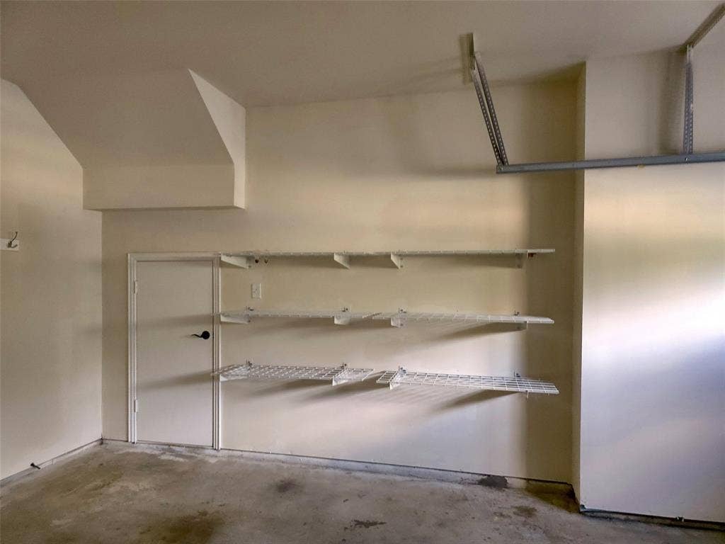 1504 Fox Run Drive, Irving, TX 75063 Interior space featuring three levels of wall-mounted wire shelving and a solid-core utility door with matte black hardware