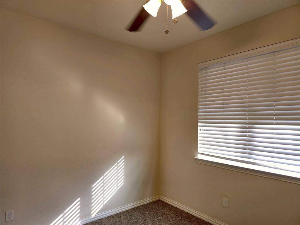 1504 Fox Run Drive, Irving, TX 75063 Neutral-toned interior walls, neutral-toned carpeting, ceiling-mounted fan with integrated lighting, and horizontal window blinds