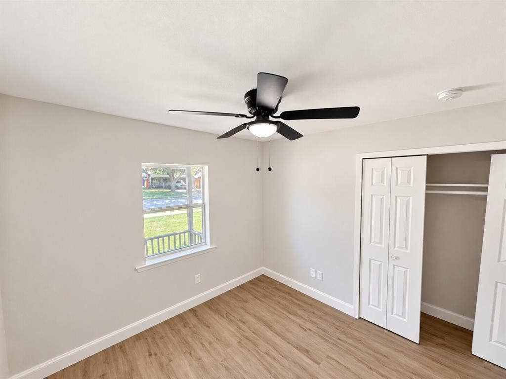 1307 Crestridge Drive, Plano, TX 75075 Neutral-toned interior featuring wood-finish flooring, a ceiling fan with integrated lighting, and a closet with bifold doors