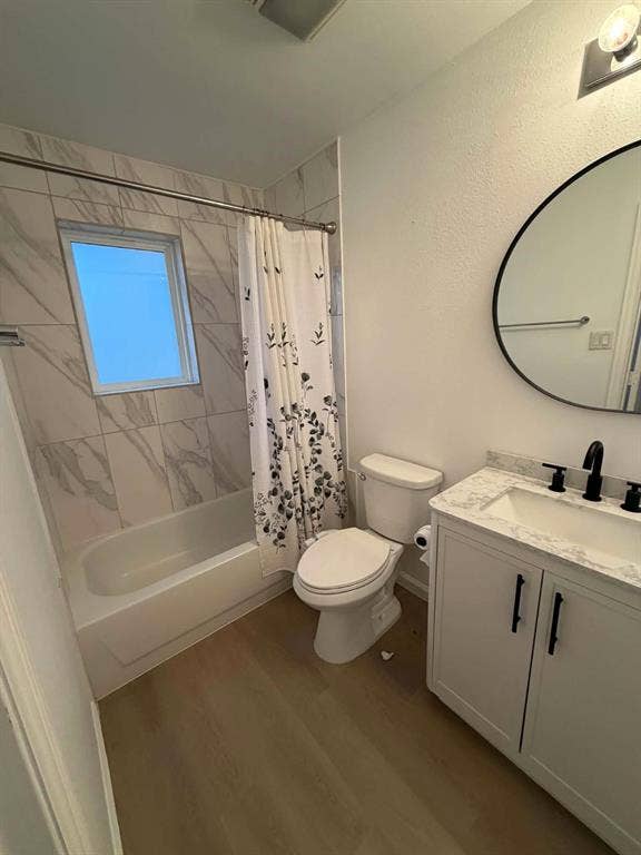 5864 Oram Street, Dallas, TX 75206 2nd Bathroom featuring a vanity with a stone-finish countertop, undermount sink, and matte black hardware, paired with a shower-tub combination featuring floor-to-ceiling stone-patterned wall tile and a circular vanity mirror