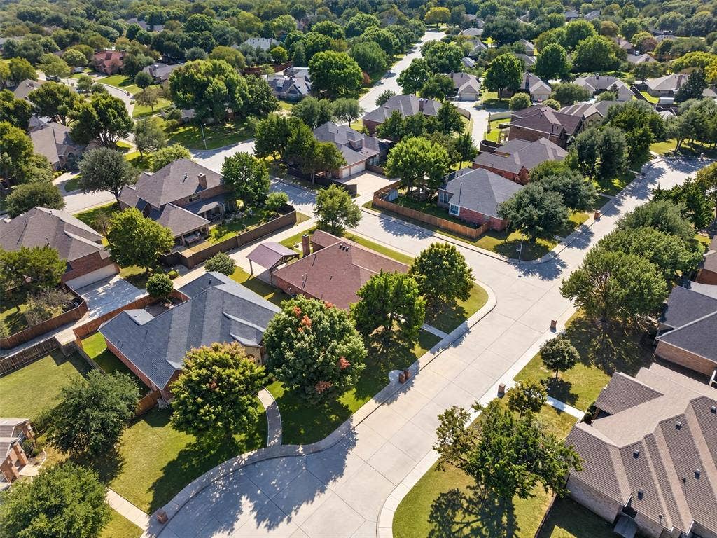 1514 Natalie Lane, Duncanville, TX 75137 Aerial perspective of a residential neighborhood featuring paved concrete streets, varying lot sizes, established mature tree canopy, and multi-pitched asphalt shingle roofs