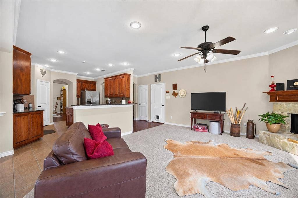 1514 Natalie Lane, Duncanville, TX 75137 Open-concept living space featuring wood-finish cabinetry, a stone fireplace hearth, recessed lighting, and a ceiling fan