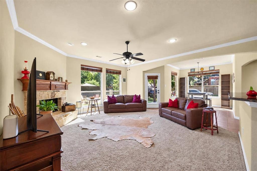 1514 Natalie Lane, Duncanville, TX 75137 Living area featuring a stone-surround fireplace with a wood mantel, vaulted ceilings, neutral wall-to-wall carpeting, recessed lighting, and large windows