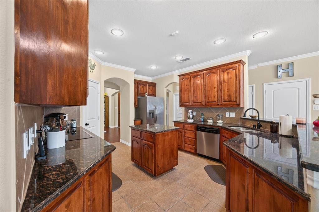 1514 Natalie Lane, Duncanville, TX 75137 Kitchen featuring wood cabinetry, stone countertops, a center island, stainless steel appliances, and recessed lighting