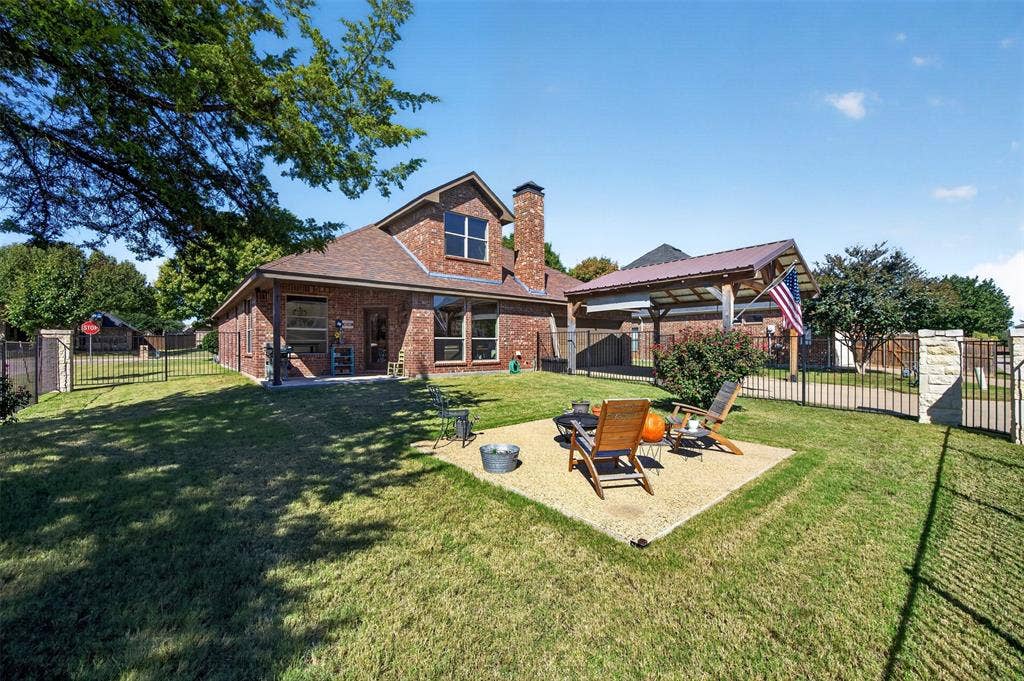 1514 Natalie Lane, Duncanville, TX 75137 Brick exterior residence featuring a gravel patio area, detached wooden pavilion, and fenced perimeter