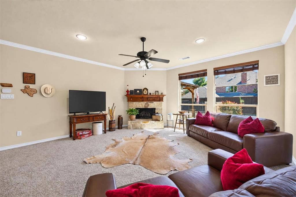 1514 Natalie Lane, Duncanville, TX 75137 Stone-surround fireplace with a wooden mantel, neutral wall paint, recessed lighting, multi-blade ceiling fan, and large windows