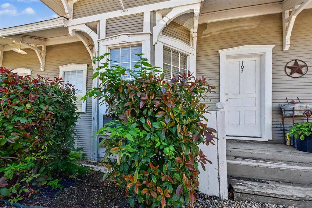 105 College Street, #107, Wylie, TX 75098 Exterior entrance featuring horizontal lap siding, decorative corbel brackets, multi-pane windows, and a raised entry landing with stairs