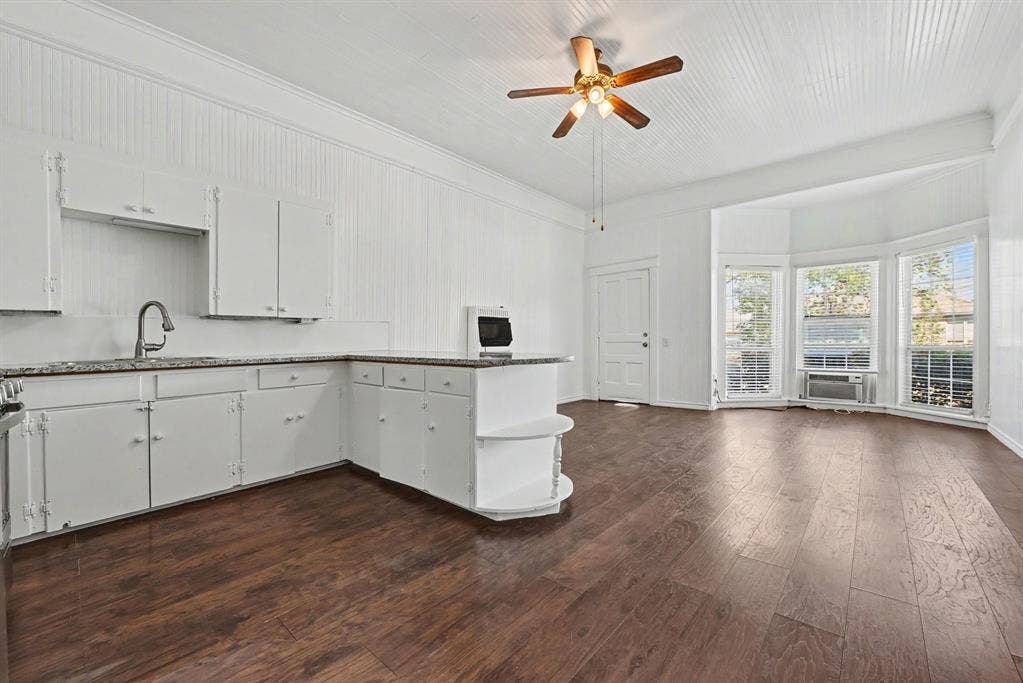 105 College Street, #107, Wylie, TX 75098 Wood-finish flooring, white paneled wall cladding, vaulted ceiling, and bay windows