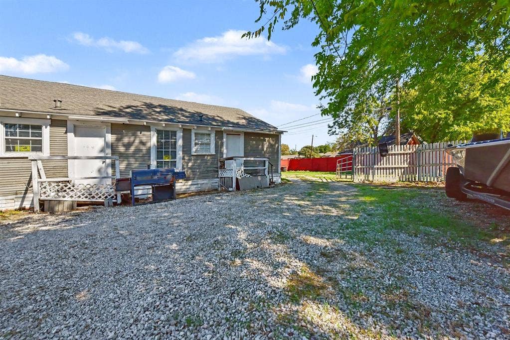 105 College Street, #107, Wylie, TX 75098 Exterior siding, gravel driveway, and perimeter wood fencing