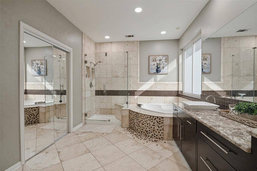 The downstairs Primary Suite has a window seat, direct outdoor access, and a generous bath with dual vanities, soaking tub, and separate shower.