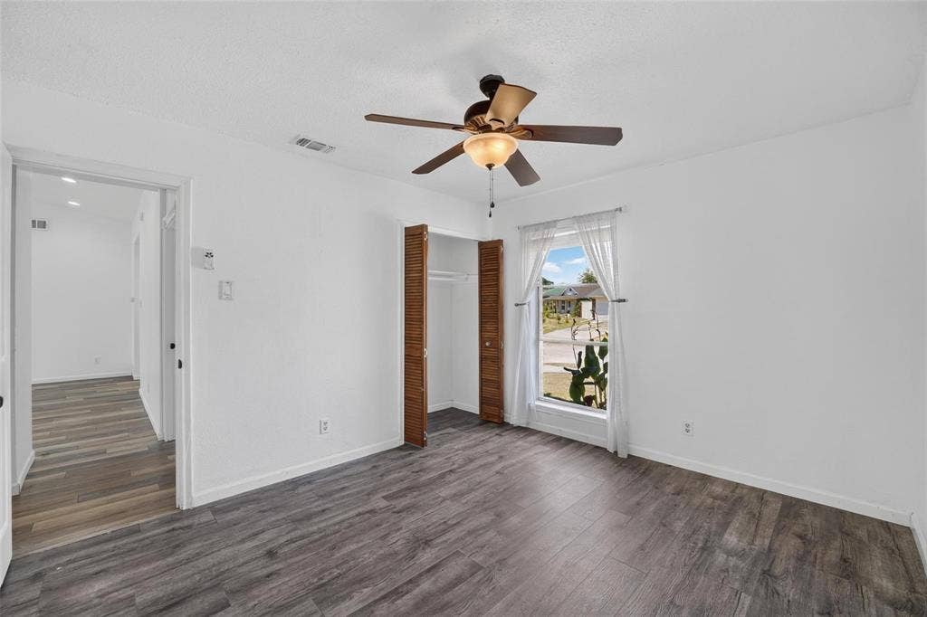 2130 Bowie Drive, Carrollton, TX 75006 Room featuring wood-finish flooring, a ceiling fan with integrated lighting, and a closet with louvered doors