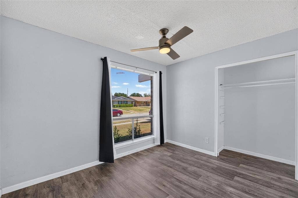 2130 Bowie Drive, Carrollton, TX 75006 Room featuring wood-finish flooring, a large picture window, and a ceiling fan with integrated lighting