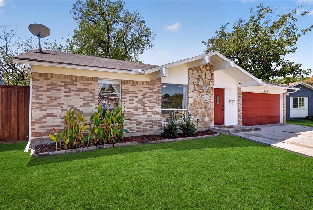 2130 Bowie Drive, Carrollton, TX 75006 Single-story exterior featuring multi-toned brick masonry, natural stone accent facade, prominent gabled roofline, and attached two-car garage