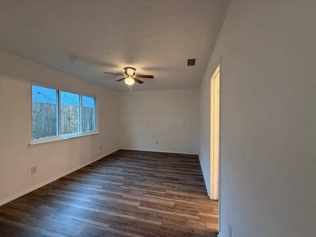 Interior room featuring wood-finish flooring, a multi-pane window, and a ceiling-mounted fan with light fixture