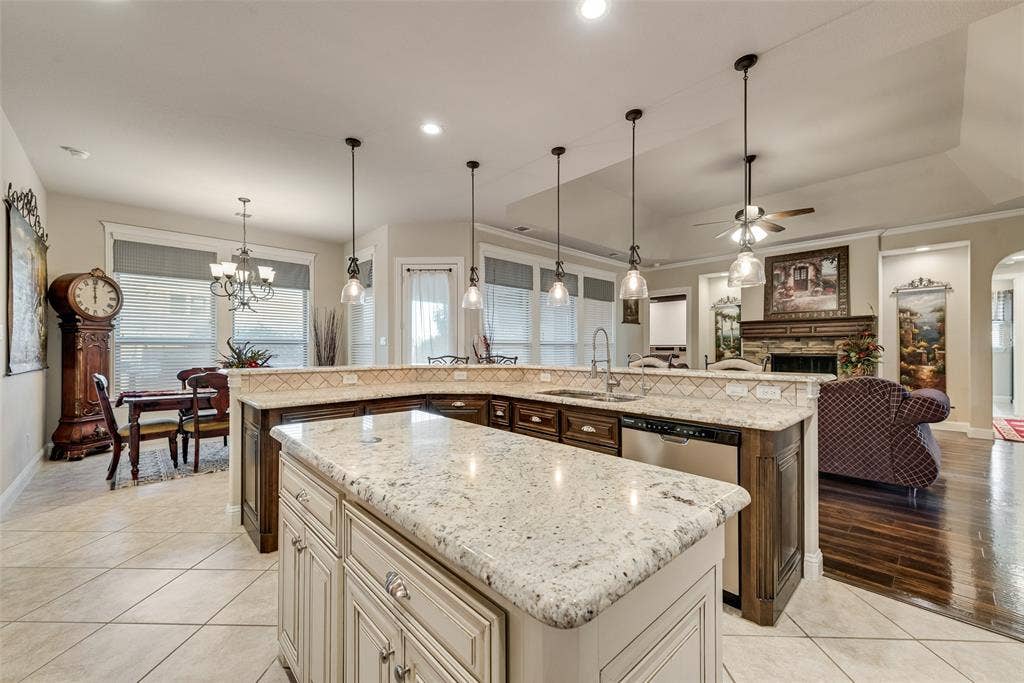7231 Judy Drive, Ovilla, TX 75154 Kitchen featuring a center island, stone-surfaced countertops, custom cabinetry, recessed lighting, and pendant illumination