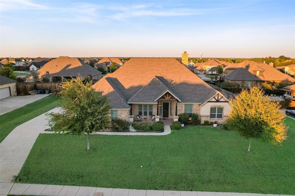 7231 Judy Drive, Ovilla, TX 75154 Single-story residence featuring a brick and stone exterior, a multi-gabled roofline, decorative timber framing, a concrete driveway, and mature landscaping