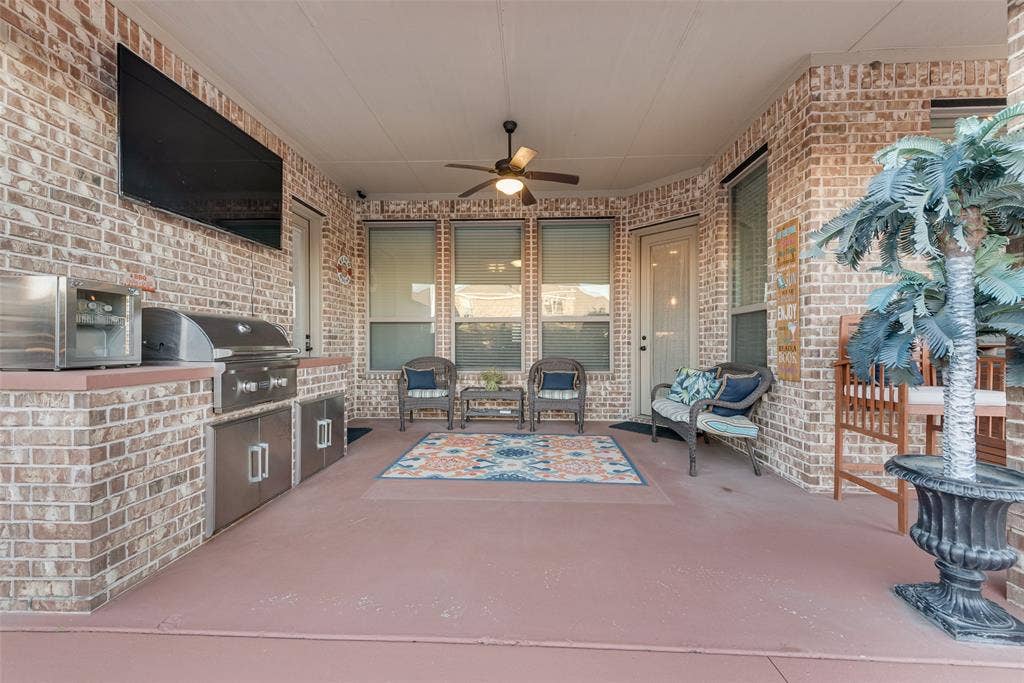 7231 Judy Drive, Ovilla, TX 75154 Covered patio featuring brick masonry, a built-in stainless steel outdoor kitchen with a grill and refrigerated storage, and a ceiling fan