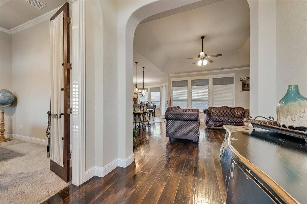 7231 Judy Drive, Ovilla, TX 75154 Interior featuring an arched entryway, wood-finish flooring, recessed tray ceiling, and a ceiling fan with integrated lighting
