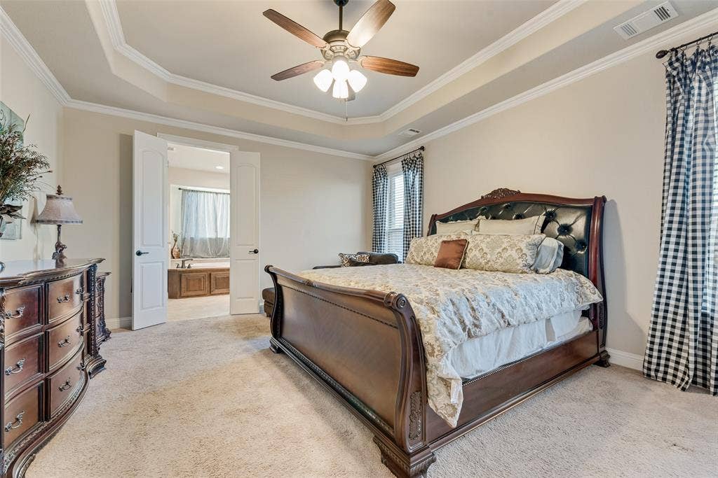 7231 Judy Drive, Ovilla, TX 75154 Tray ceiling with crown molding, plush carpeting, and a multi-blade ceiling fan with integrated lighting