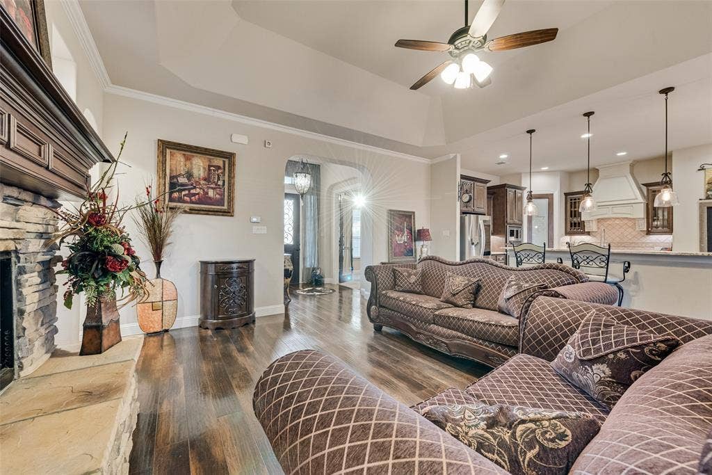 7231 Judy Drive, Ovilla, TX 75154 Living area featuring a vaulted ceiling, stone-surround fireplace with a wooden mantel, wood-finish flooring, and recessed lighting