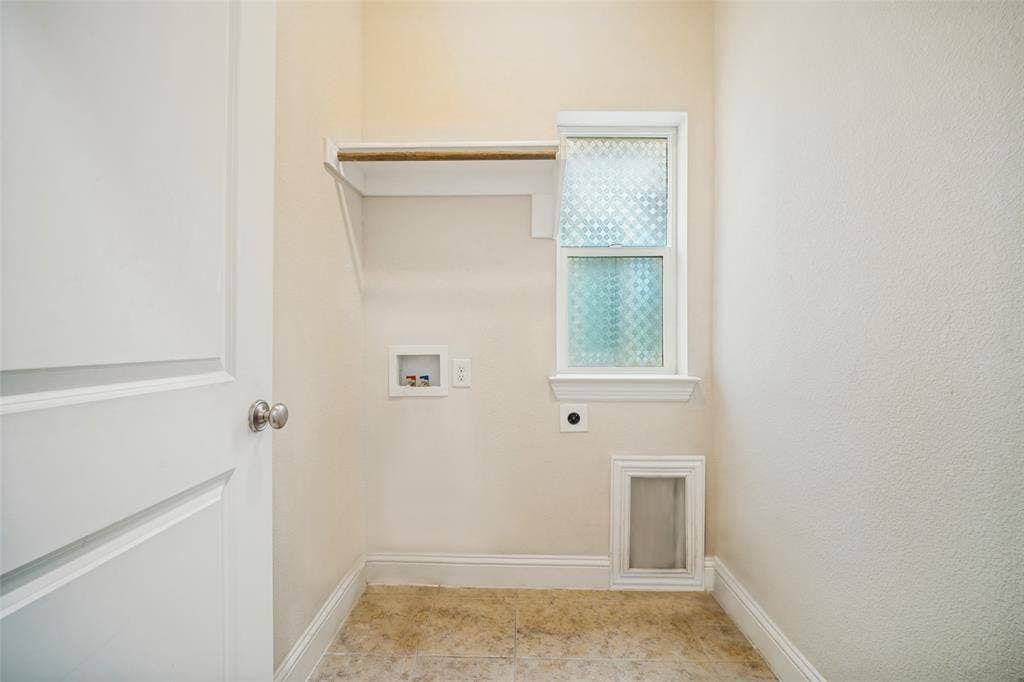Utility area featuring a frosted glass window, built-in shelving with a hanging rod, dedicated plumbing connections, and a built-in pet door