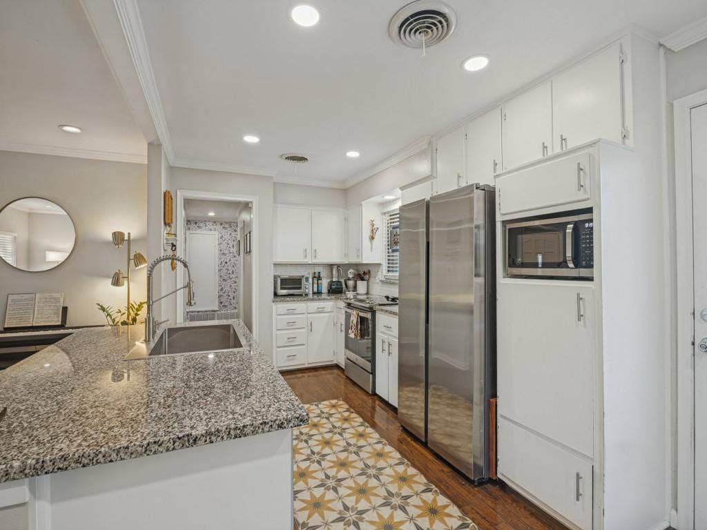 200 S Weatherred Drive, Richardson, TX 75080 Kitchen featuring stone countertops, stainless steel appliances, white cabinetry, recessed lighting, and wood-finish flooring