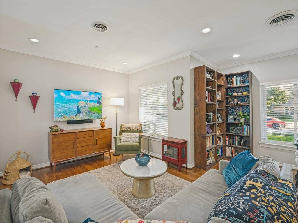 200 S Weatherred Drive, Richardson, TX 75080 Living area featuring wood-finish flooring, recessed lighting, built-in floor-to-ceiling shelving, and windows equipped with horizontal blinds